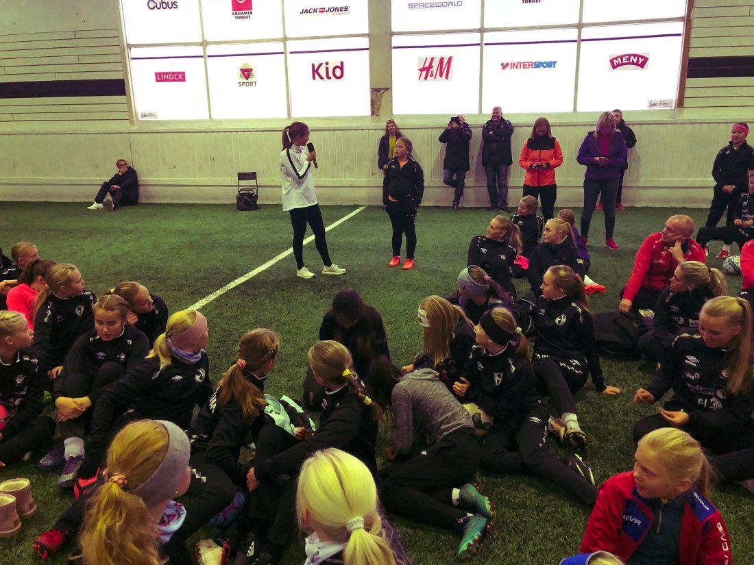 Bilde fra innendørs fotballhall der Guro Reiten snakker med jentespillere fra Elverum Fotball.